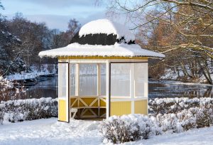 Traditional vintage yellow shelter during winter with river in t